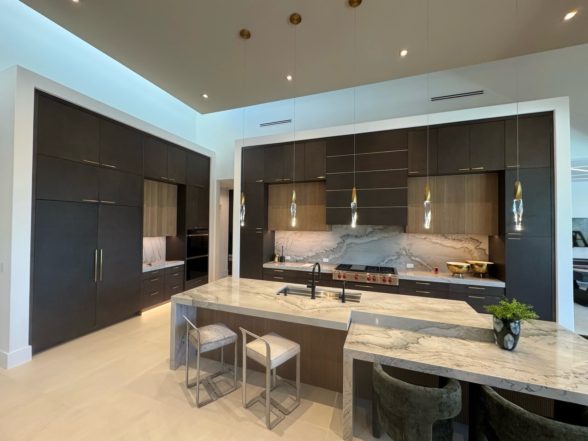 Dominion Luxury Home Tour kitchen in espresso oak with fluted hood surround and brass accents by Amaya