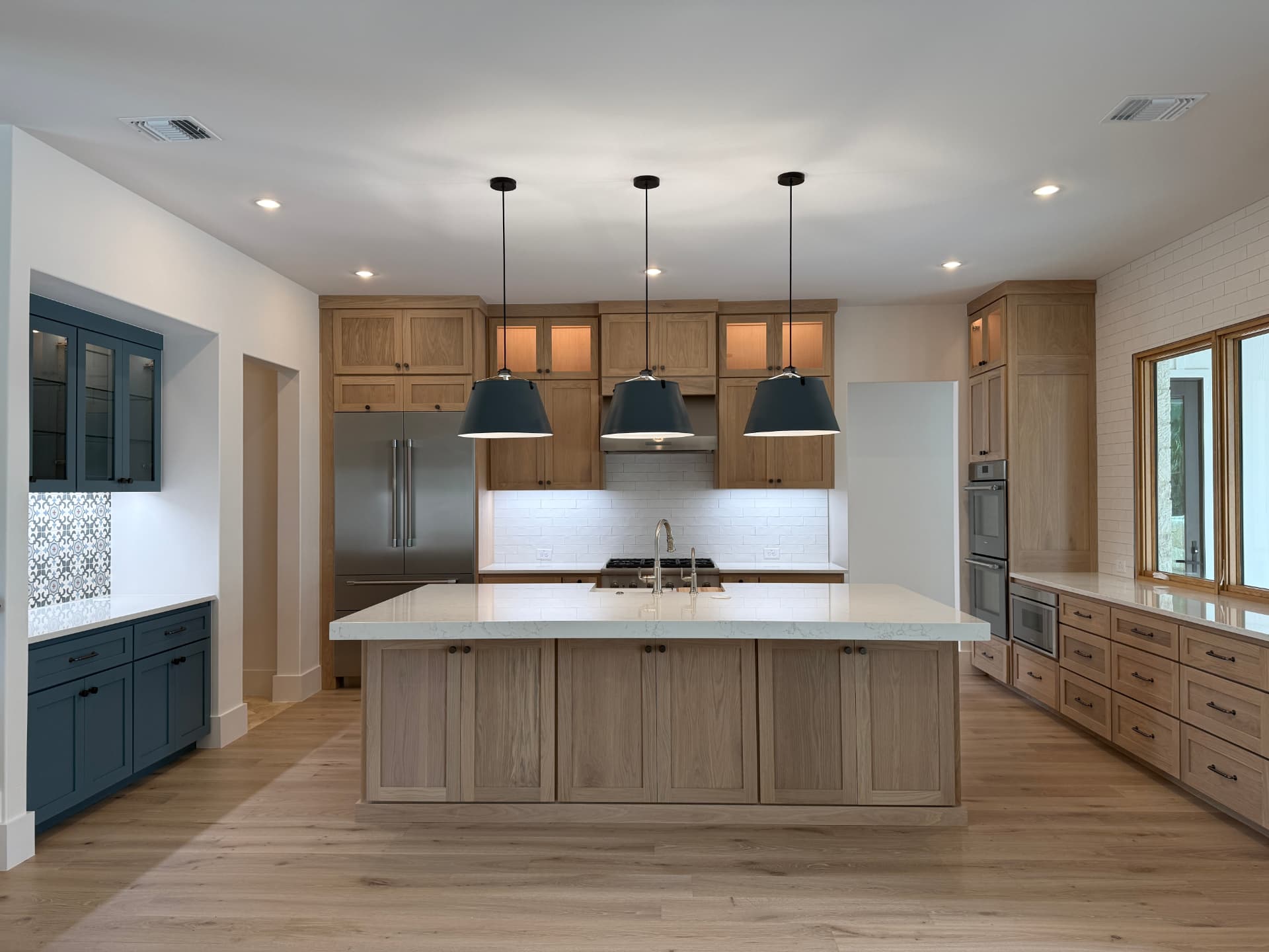 Finished custom white oak kitchen installed by Amaya, matching the approved rendering