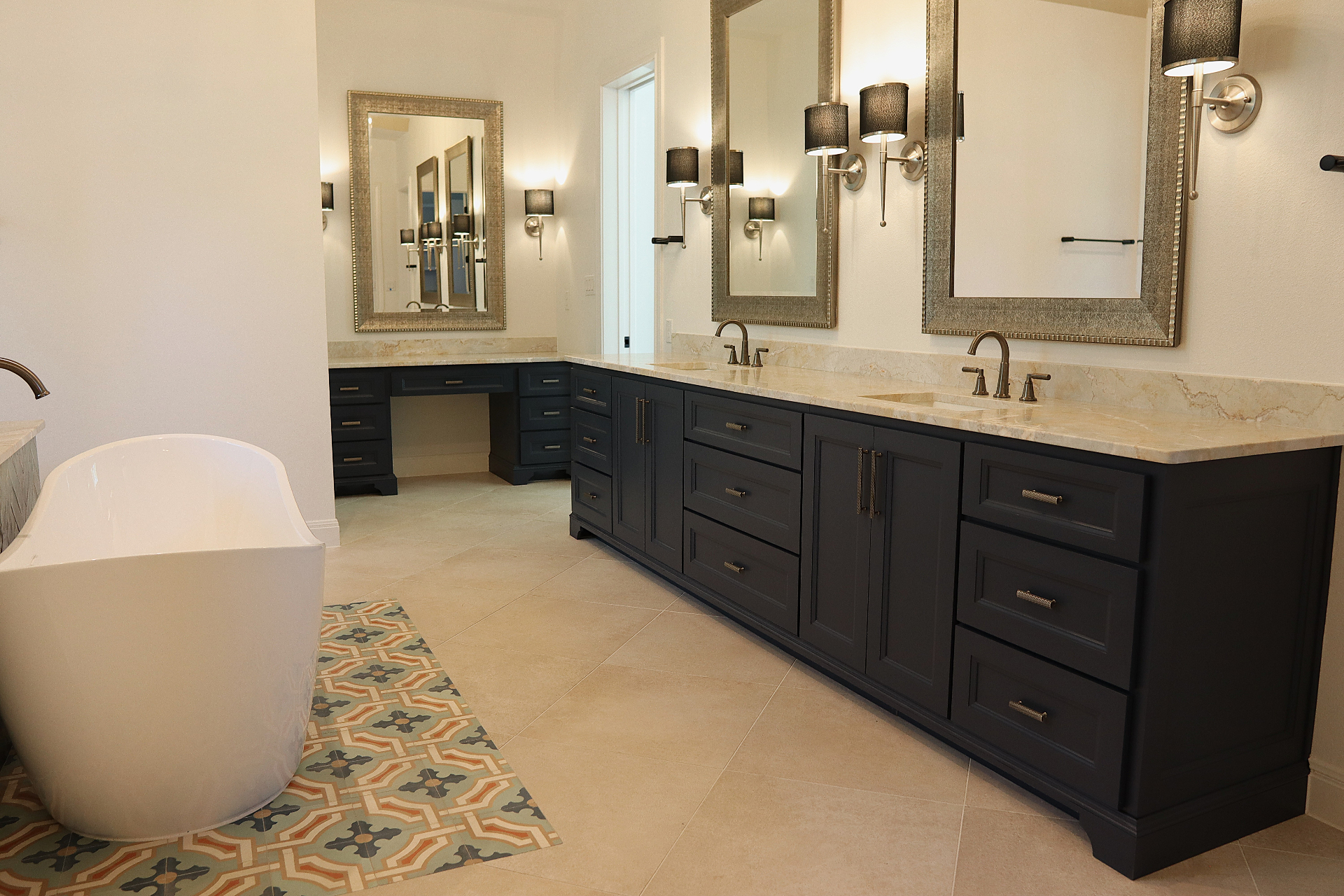 Master bath with navy dual vanity, quartzite counters, brushed nickel hardware, and a freestanding soaking tub by Amaya