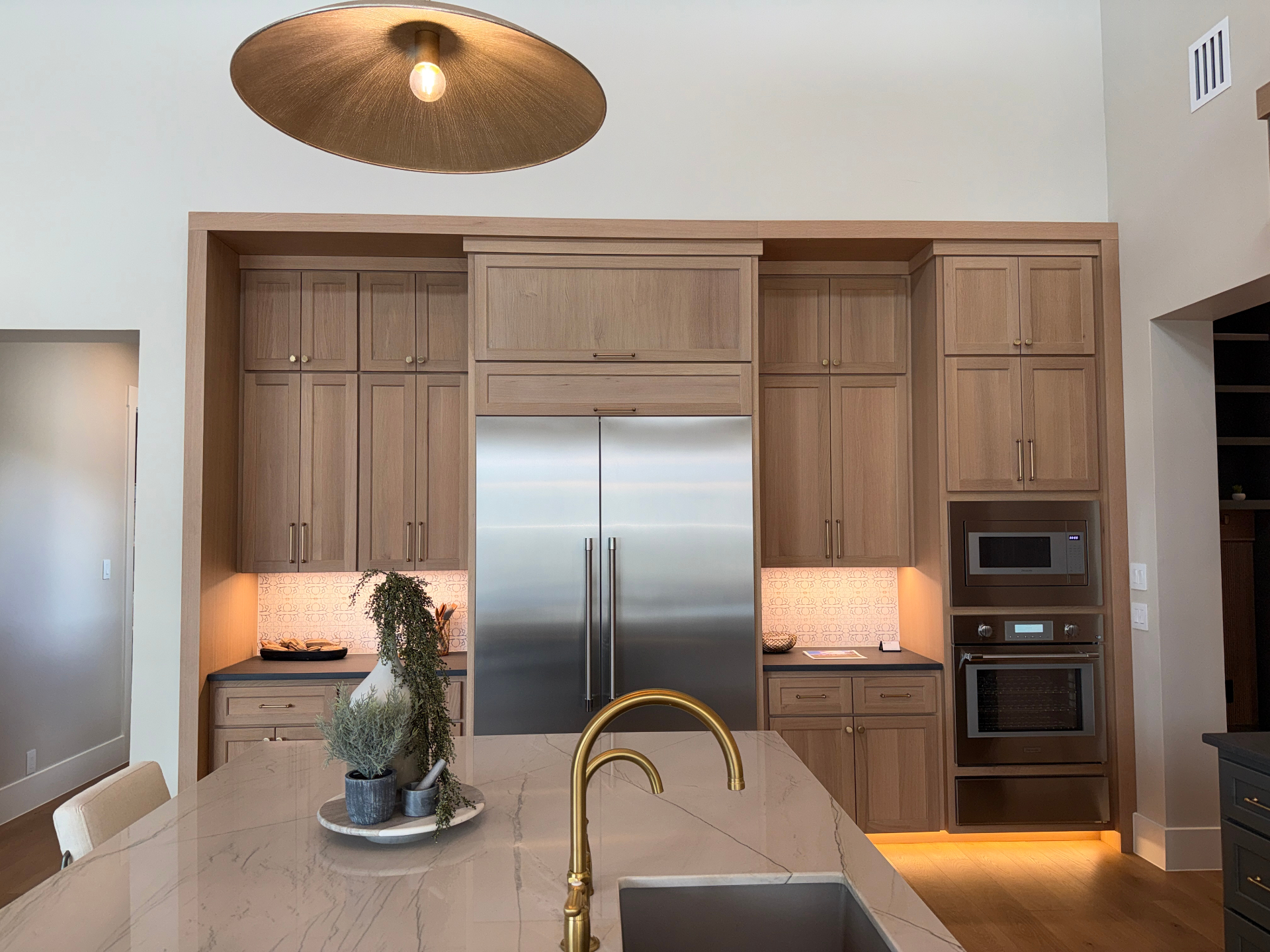 White oak shaker kitchen elevation with paneled built-in refrigerator and patterned backsplash by Amaya