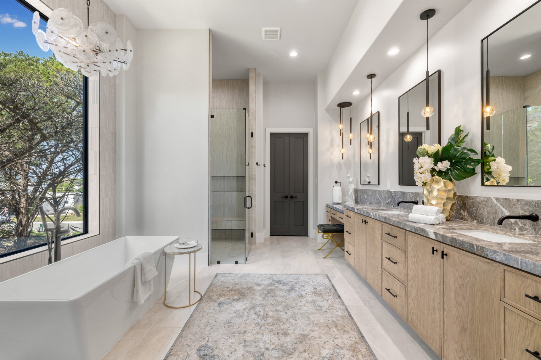 Primary bath with freestanding tub and stone-topped white oak vanity in The Dominion by Amaya