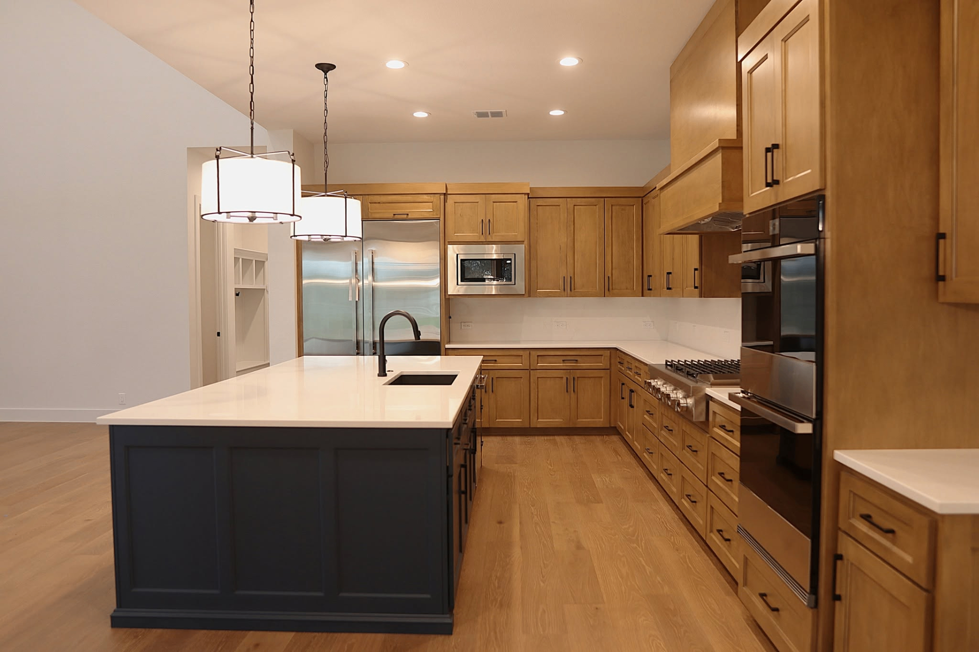 Corner view of light clear alder kitchen cabinets by Amaya